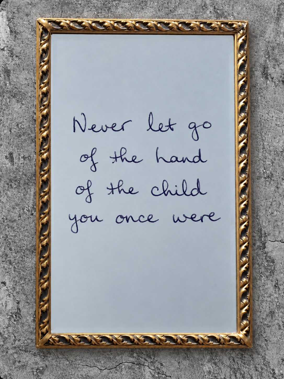 Grandma's handwritten words in a gold-framed mirror against concrete